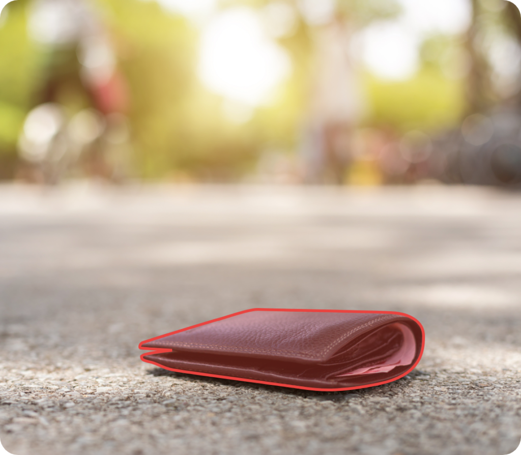 Eine verlorene Geldtasche liegt auf der Straße. Die Geldtasche liegt mit einer roten Umrandung im Fokus.